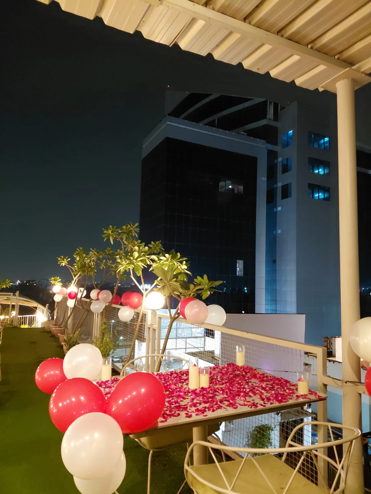 Original Chairish Cafe rooftop table for two with rose petals and candles behind WTP Jaipur